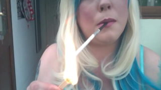 Grande et belle femme Blondie Tina Snua fumant une cigarette Slim Vogue dans un support avec une allumette